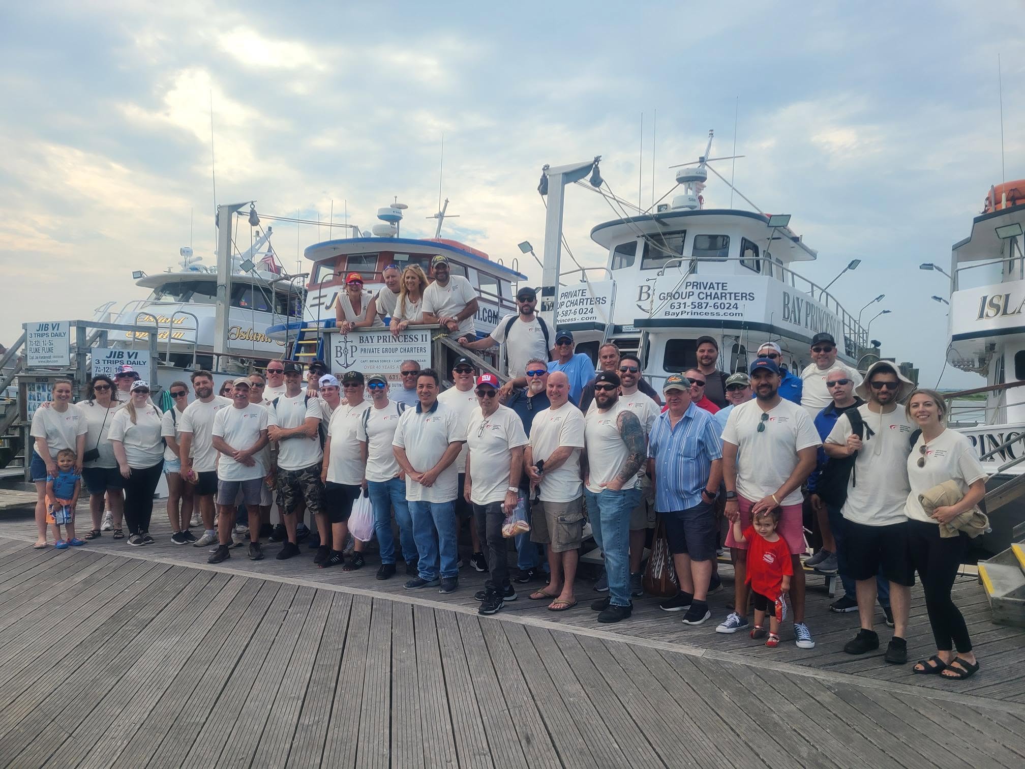 Advanced Hosted Services team, agents and partners in matching AHS shirts on the dock at the company’s annual fishing trip